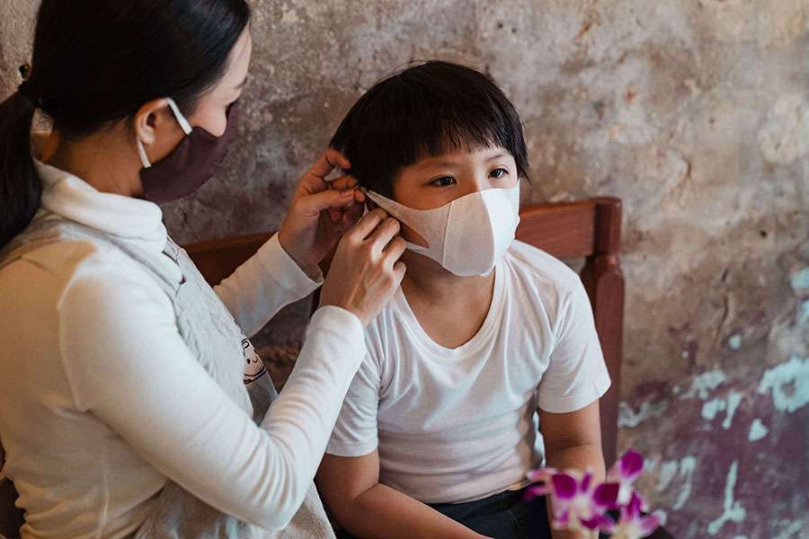 Mom-help-her-son-wearing-a-mask